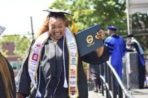 Student holding diploma smiling